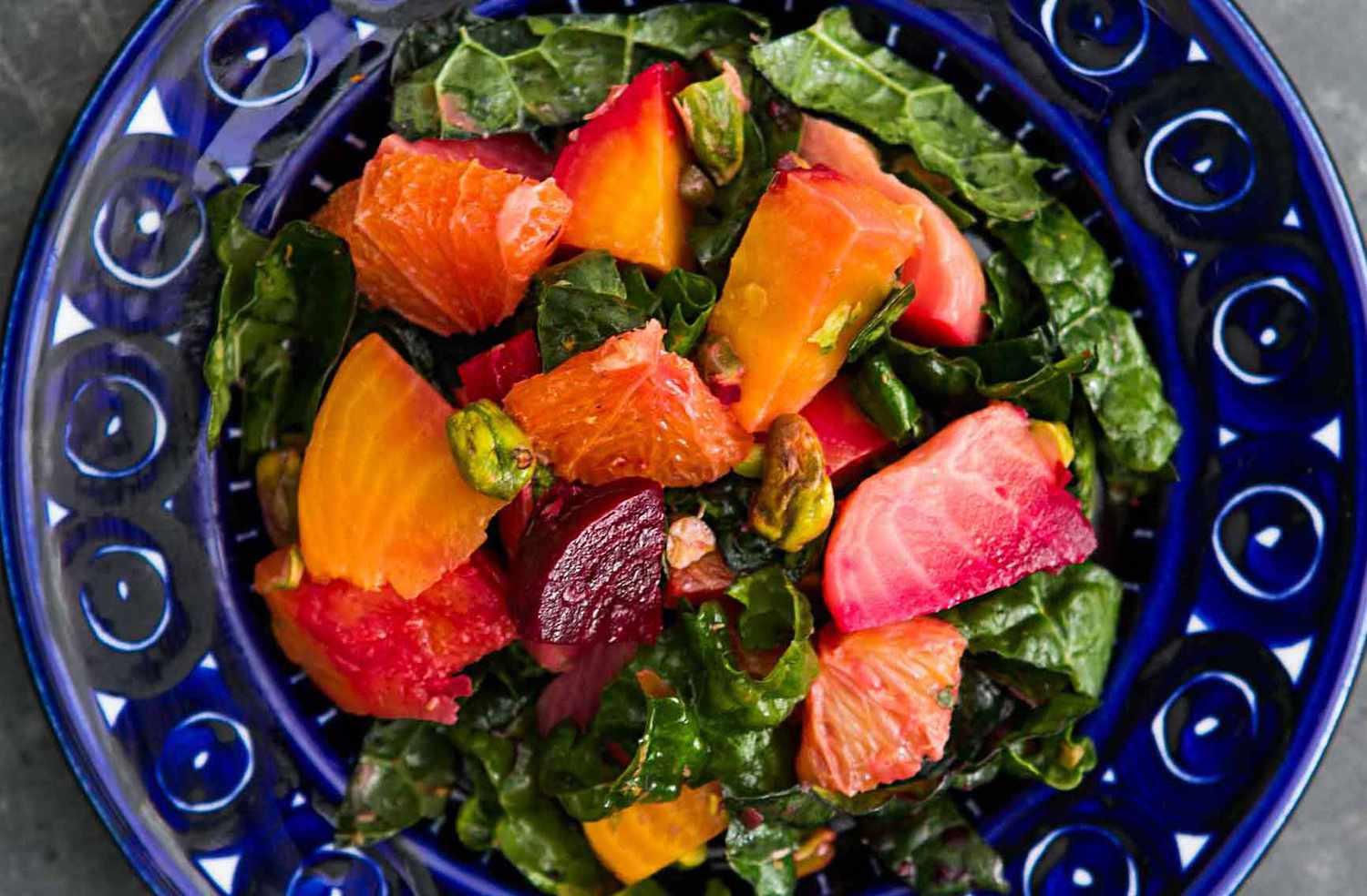 A plate with a a kale and beet salad on it, ready to eat