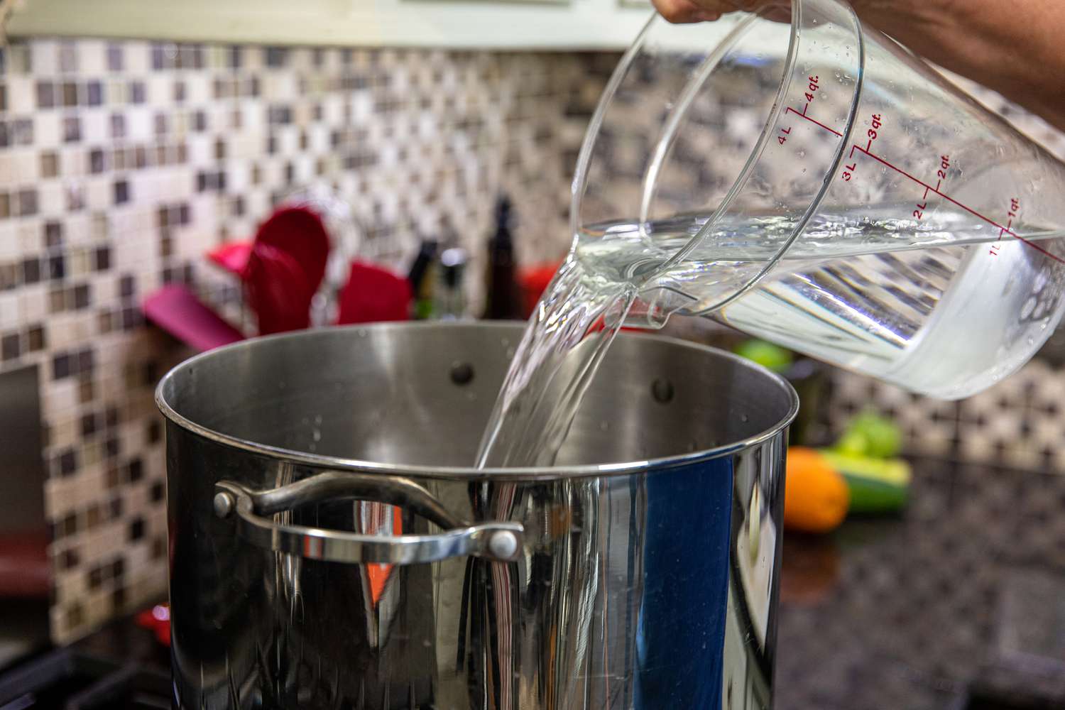 Adding water to a pot to make a citrusy brine for whole turkey.