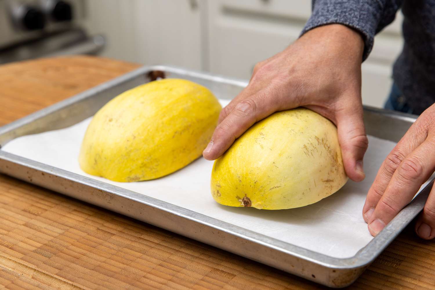 Halved Spaghetti Squash Placed on Lined Baking Pan, Flesh Side Down for Winter Gourd Soup Recipe