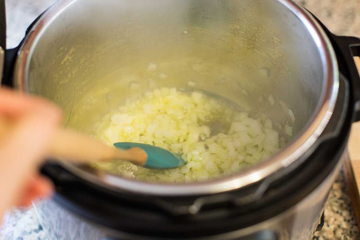 Onions sauteeing in an instant pot to make pressure cooker meatballs.