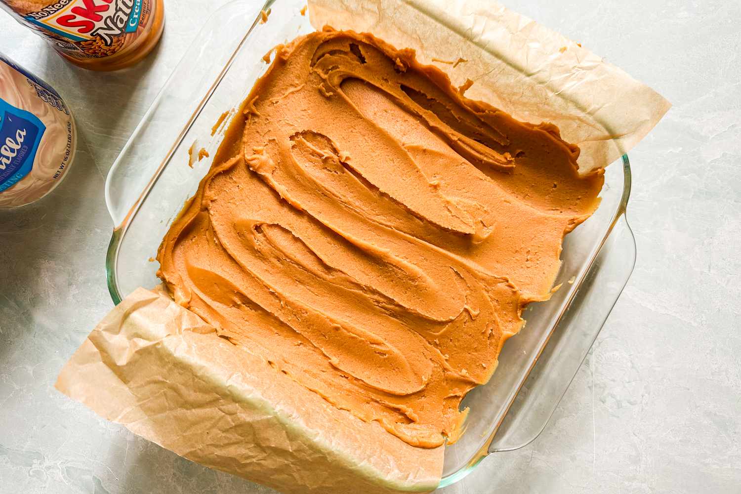 Peanut butter fudge spread into a glass baking dish