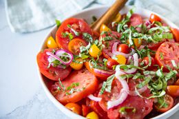Bowl of Simple Summer Tomato Salad with a Serving Spoon 