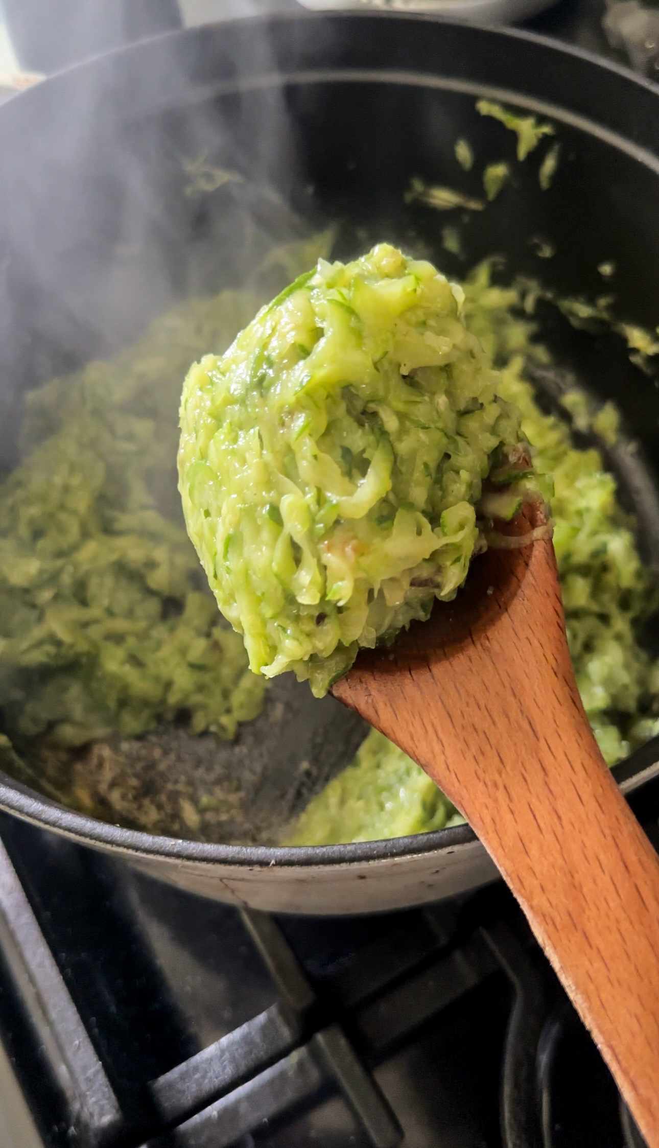 grated zucchini cooked down in a pot for making lemony zucchini pasta