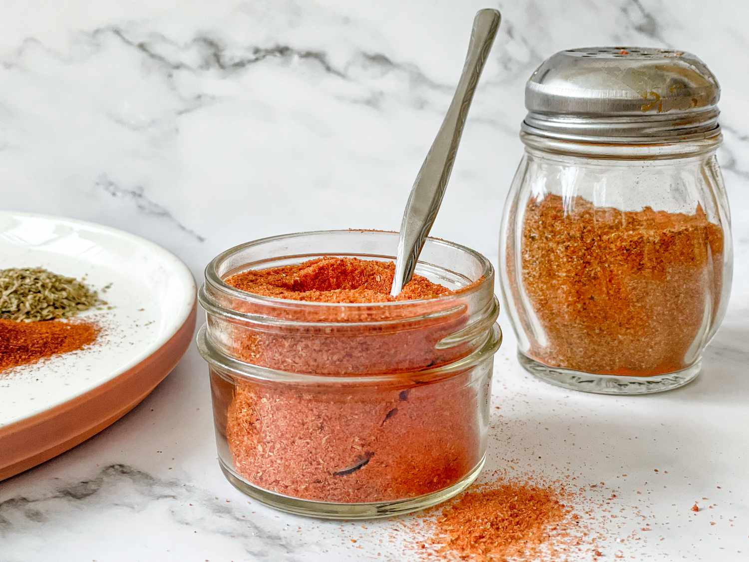 Jar of Sazon Spice with Spoon and in Background, a Shaker