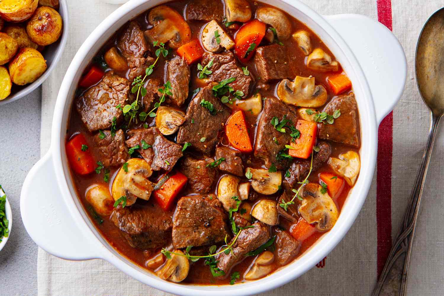 A white serving bowl with beef stew