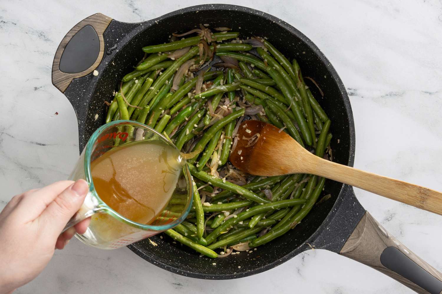 chicken broth added to the pan with the green beans for creamy coconut lime chicken recipe 