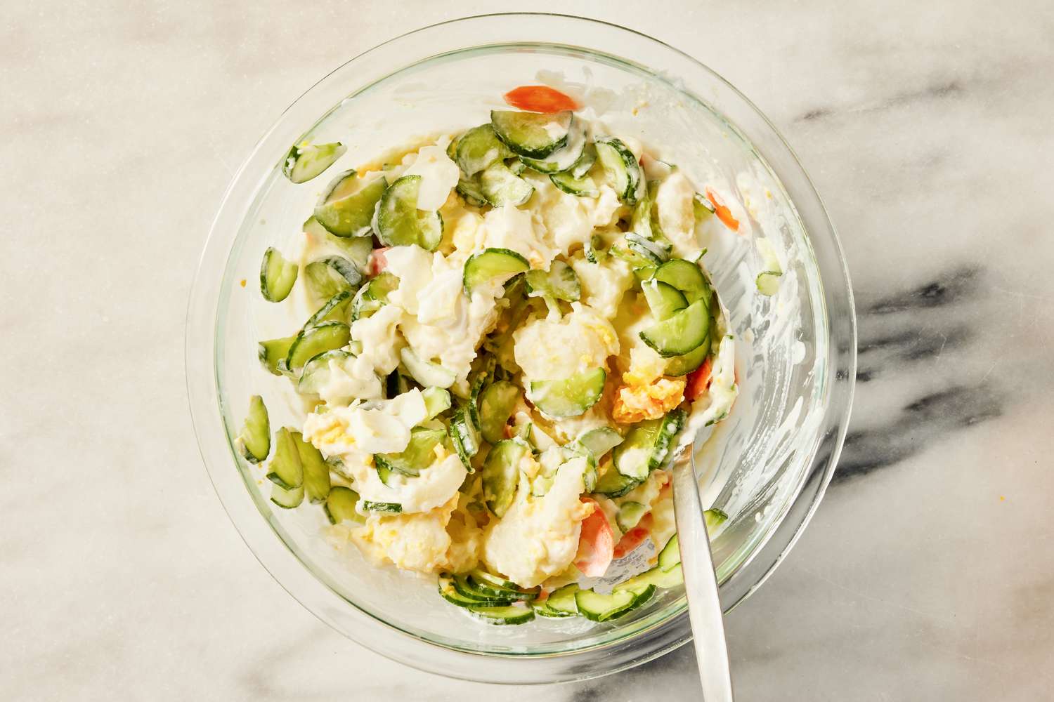 eggs, cucumbers, and carrots added to bowl of potatoes for Korean-style potato salad recipe