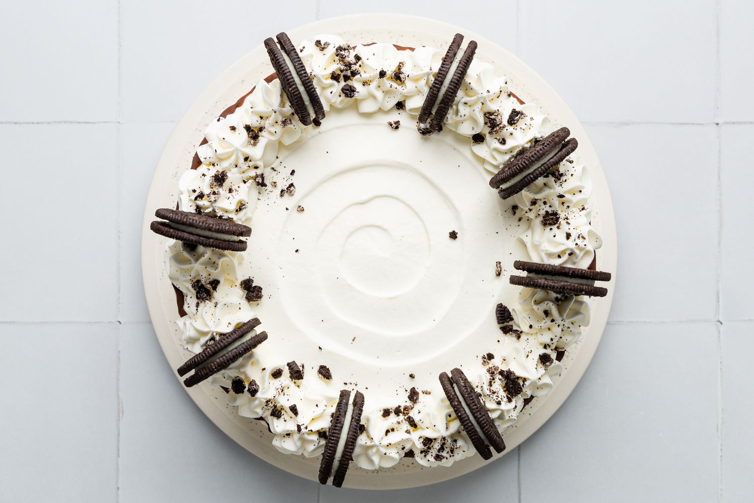 Plate of Oreo Ice Cream Cake Decorated With Whole Oreos and Oreo Crumbs 