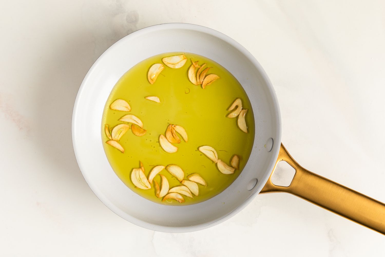 Garlic chips in olive oil in a small saute pan