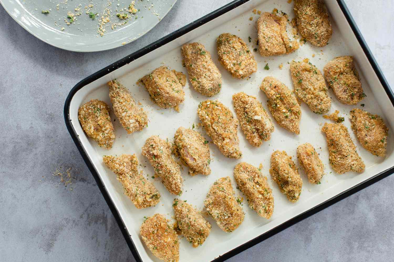 Breaded chicken set on a baking dish to make a chicken nuggets recipe.