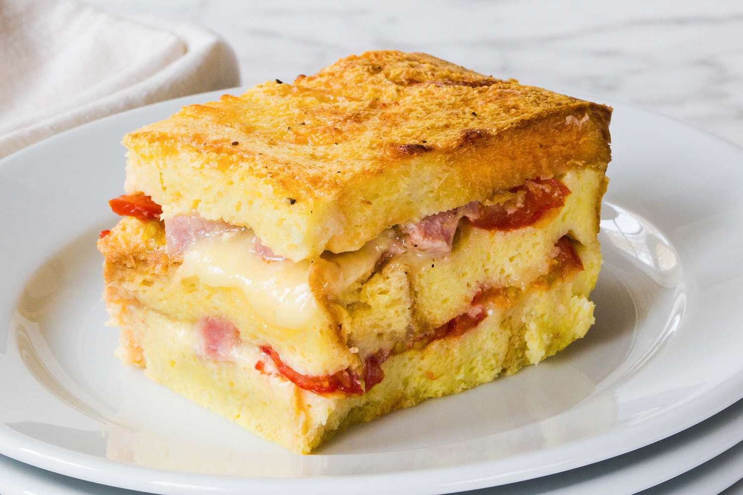 ham and cheese breakfast casserole slice on a white plate