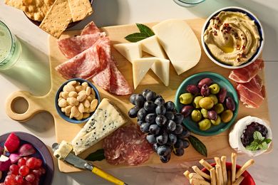 Charcuterie board with cheese meats grapes and accompaniments