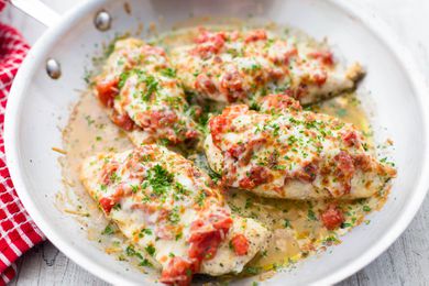 Cheesy Bruschetta Chicken Cutlets in a stainless steel skillet