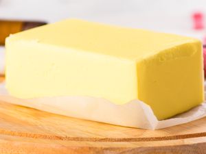 A close-up of a large block of butter on a piece of wax paper
