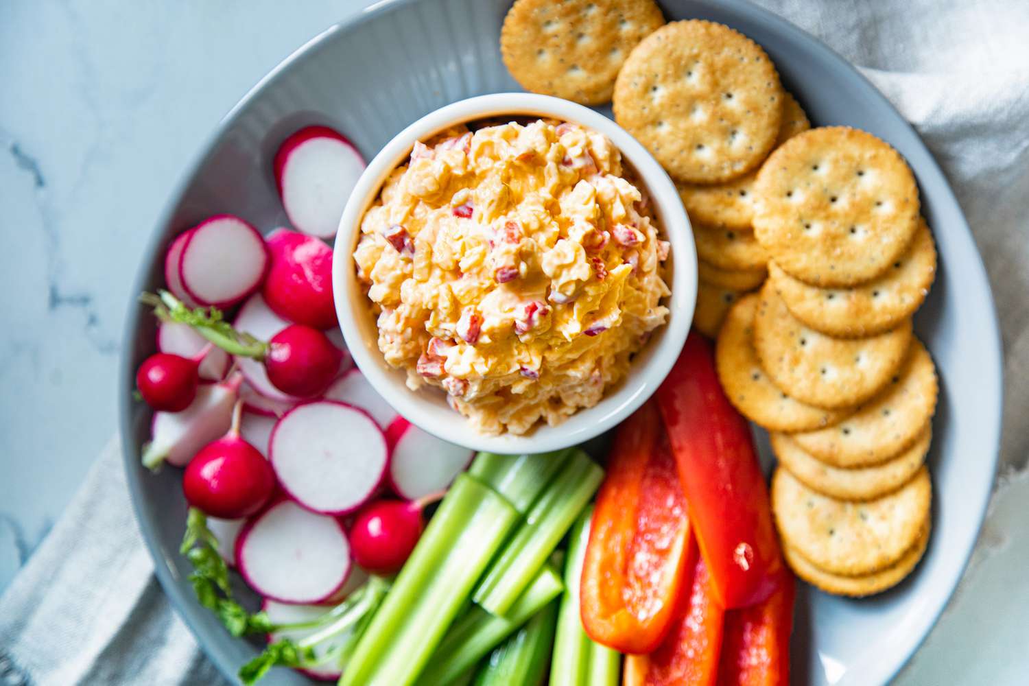 Pimento Cheese in a Bowl on Platter with Sliced Vegetables and Crackers