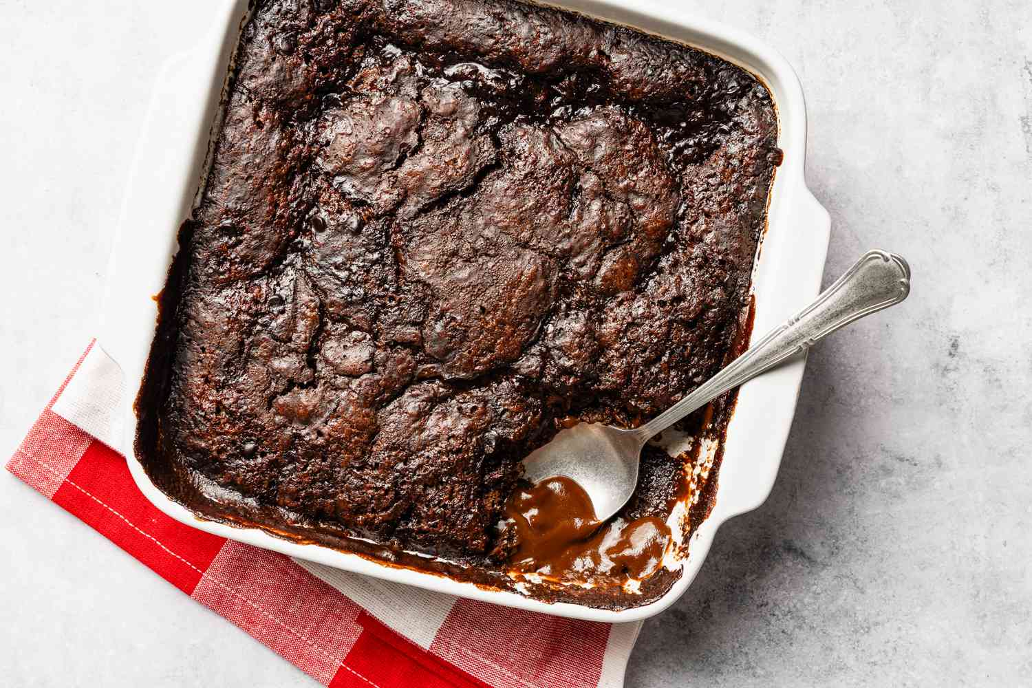 chocolate pudding cake in a baking pan with a piece cut out