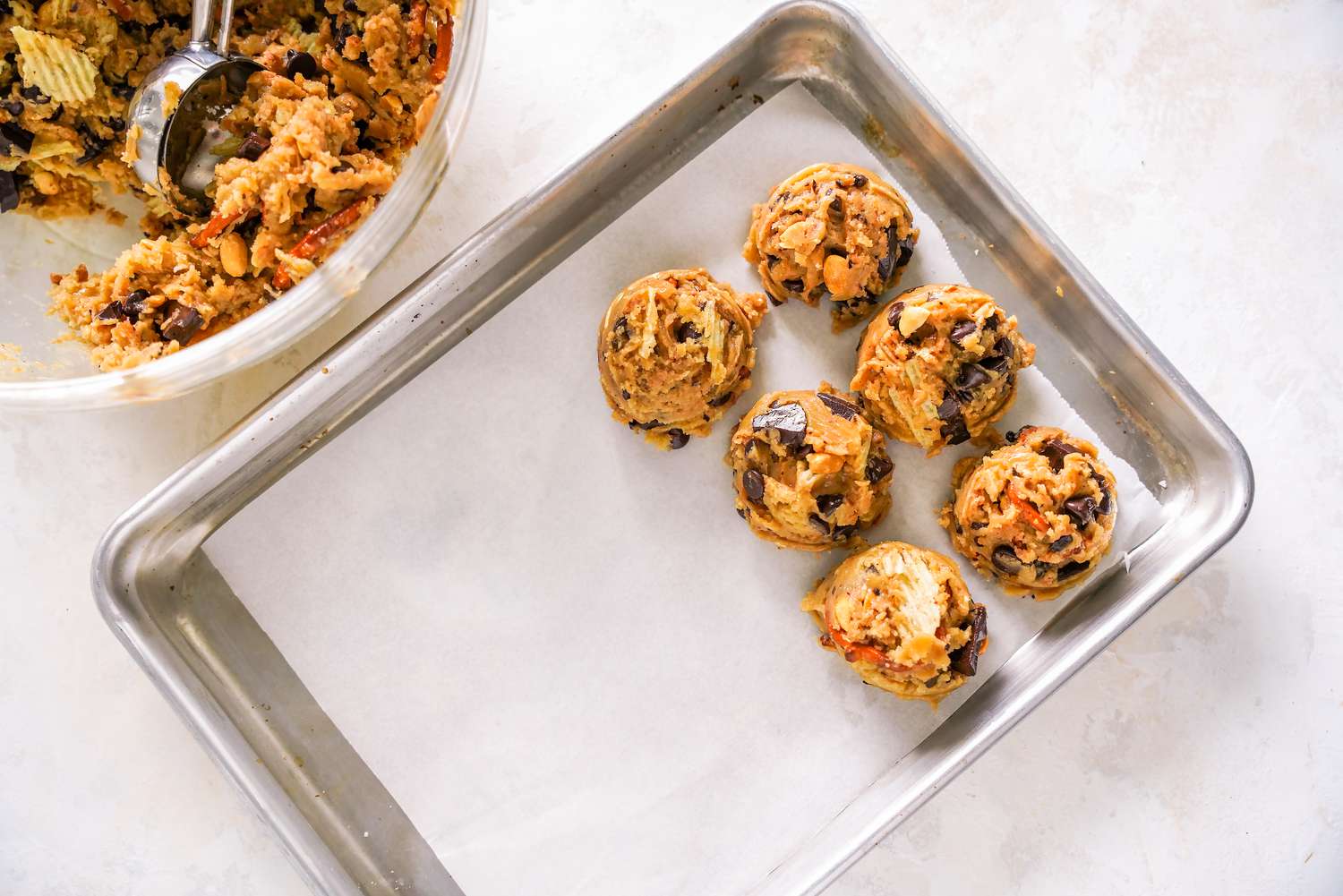 Ice Cream Scoop Used to Scoop Batter Onto a Parchment Lined Baking Sheet From the Bowl With the Rest of the Dough 