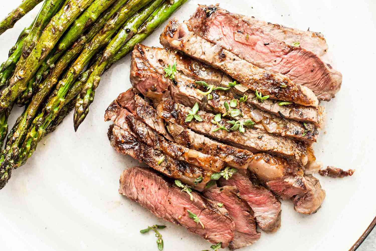 Grilled Ribeye Steak on a platter with asparagus