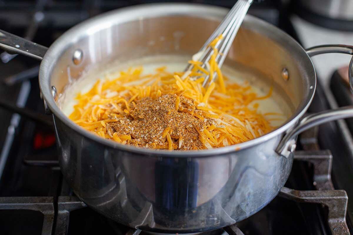 Shredded cheese and spices add to the saucepan to make the Best Cheesy Cauliflower.