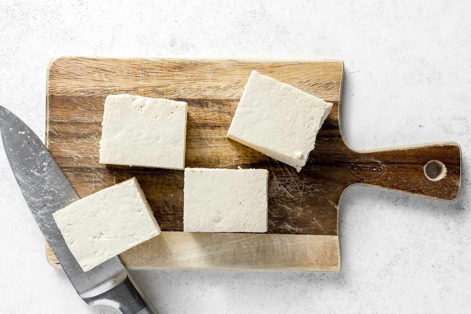 Defrosted Block of Tofu Cut into Four Blocks on a Cutting Board for Copycat Chipotle Sofritas Recipe