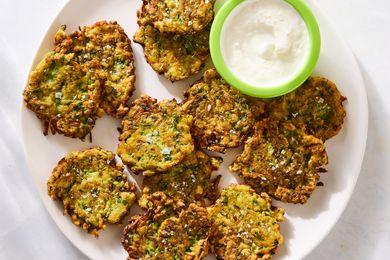 Plate of zucchini fritters with a side of dipping sauce