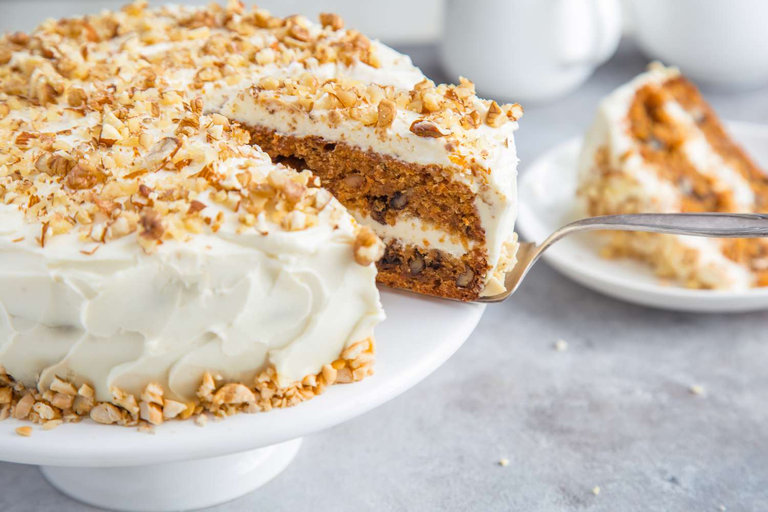 Side view of a layer carrot cake with cream cheese frosting, with a slice cut out