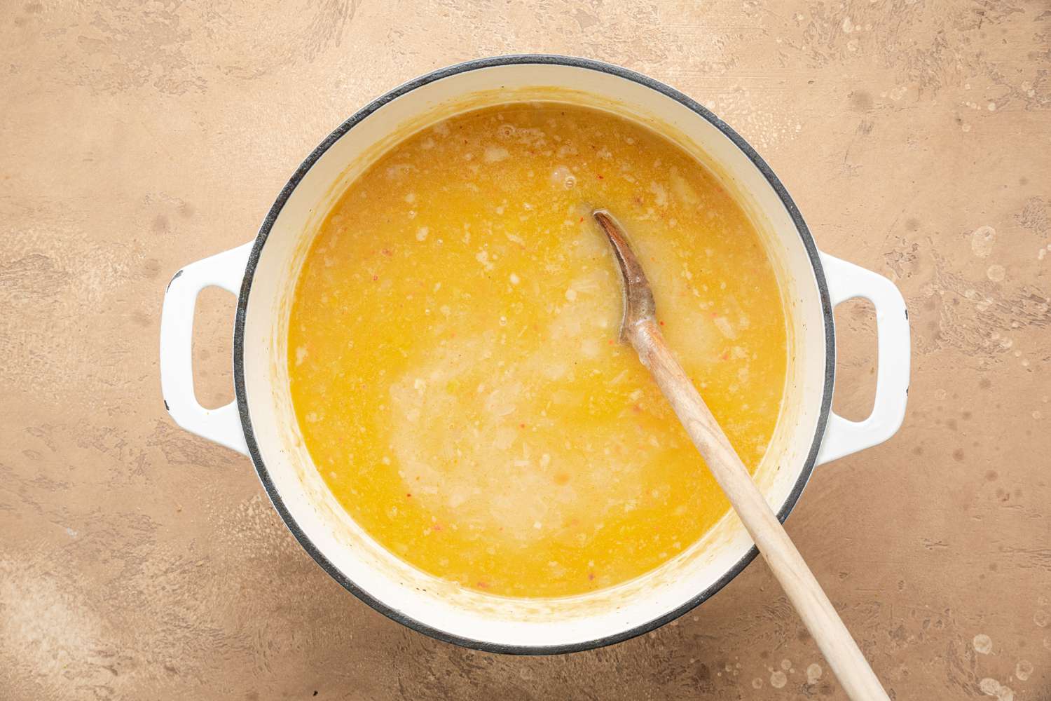 Pot of Cooked Creamy White Bean Soup with a Wooden Spoon 