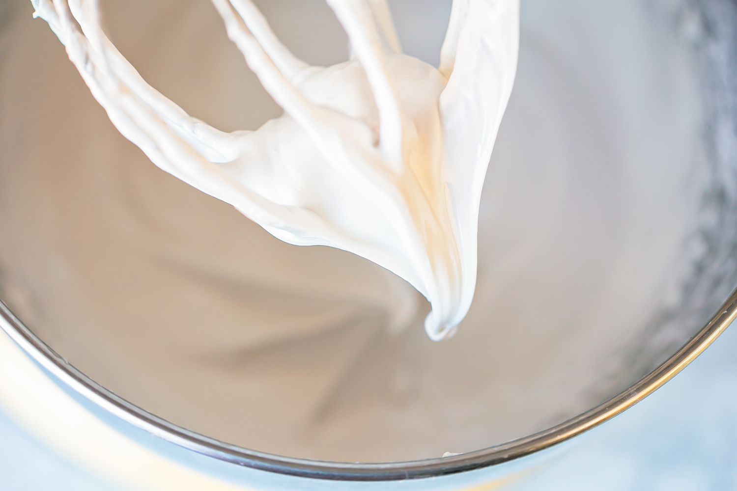 Royal frosting for gingerbread house decorations on a whisk.