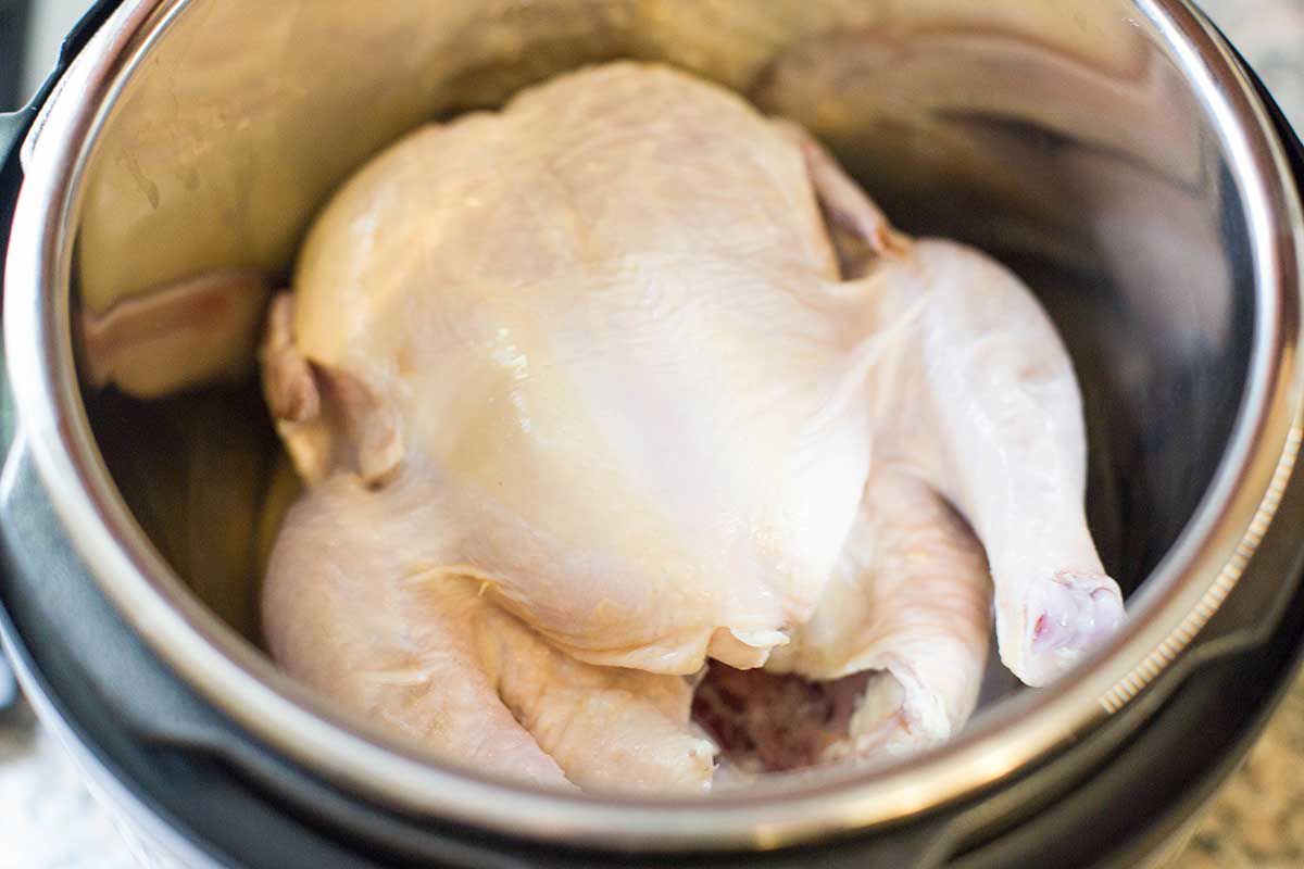 A whole chicken inside an instant pot to make instant pot soup recipes.
