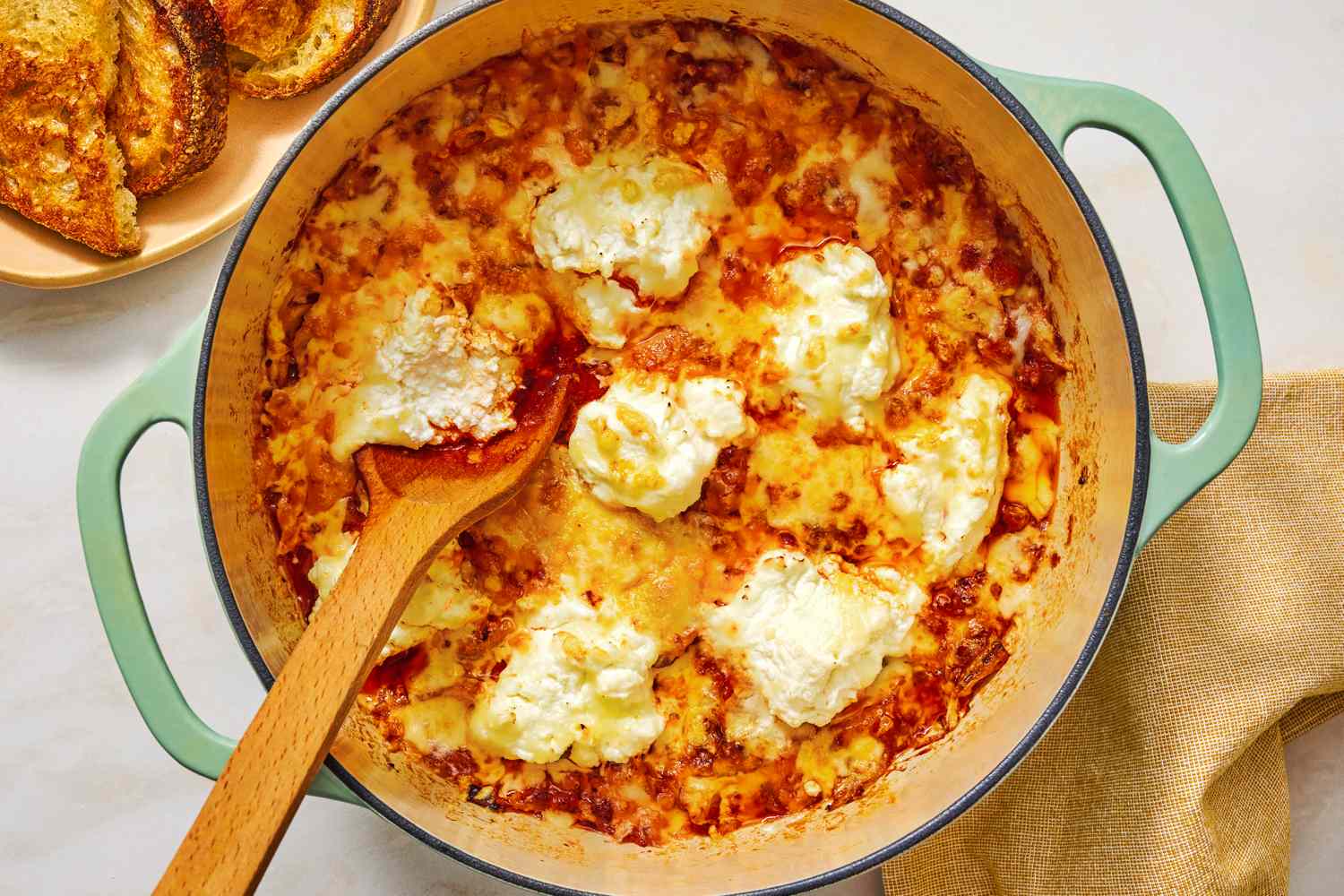 Braised cabbage lasagna in a pot with a wooden spoon