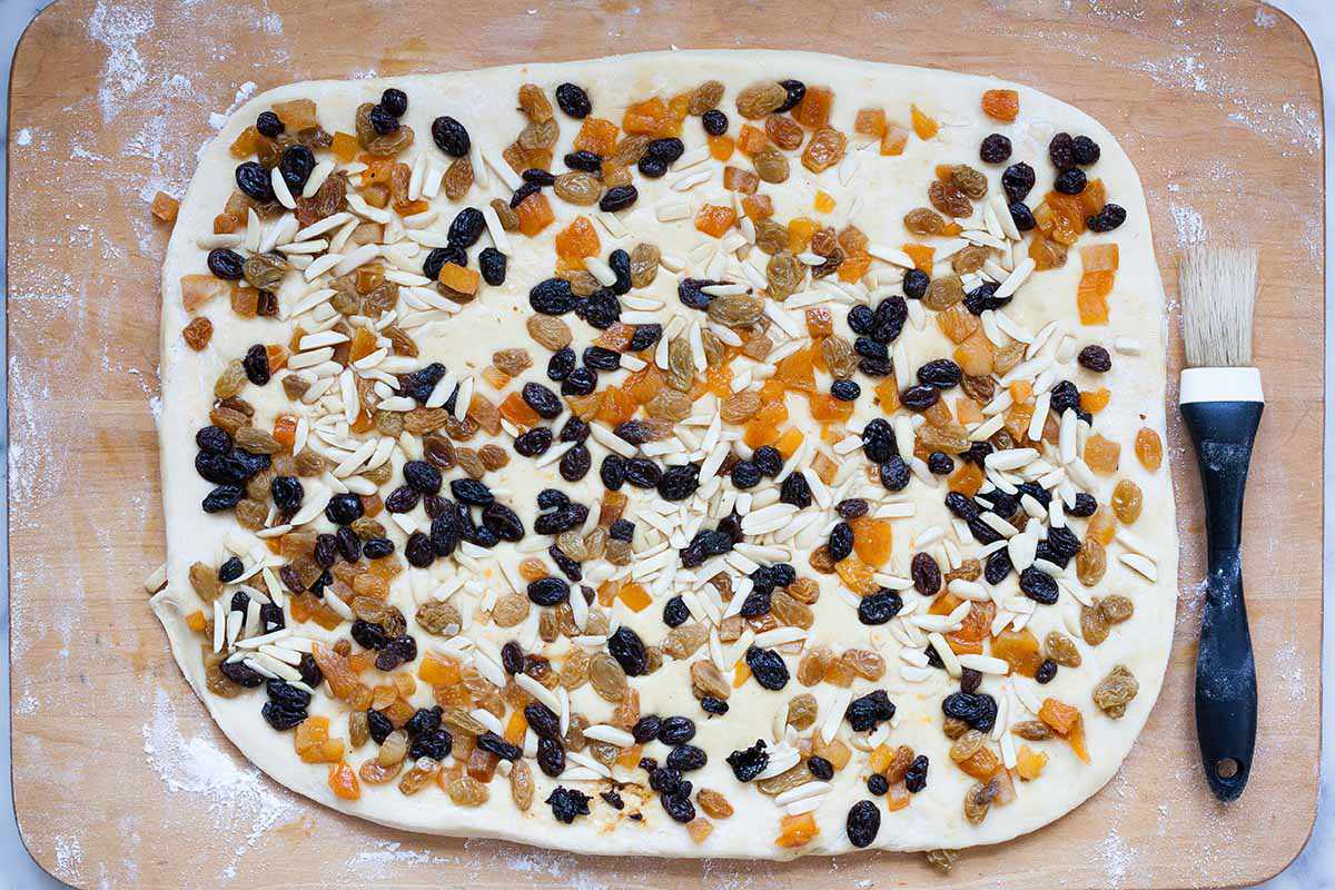 Rectangle of homemade panettone with fruit and almonds.