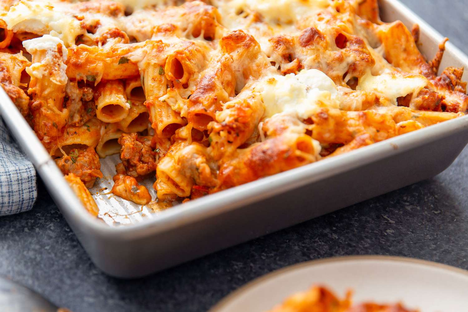 Italian Sausage Pasta Bake in a baking dish with one serving scooped out