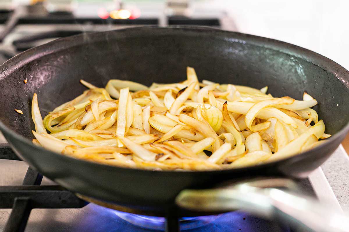 Best Crockpot Chicken and Rice Casserole add the onions to the cast iron pan