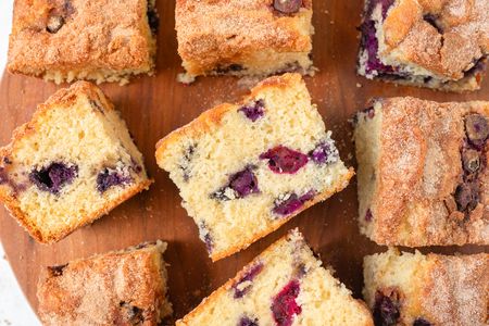 Overhead view of multiple blueberry coffee cake slices on a wooden cutting board