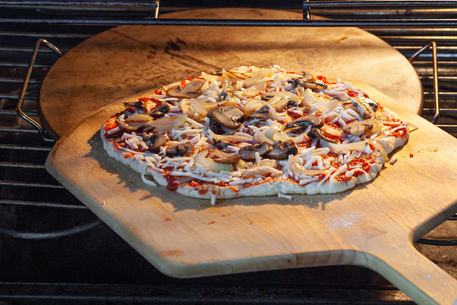 Transferring pizza dough onto pizza stone.