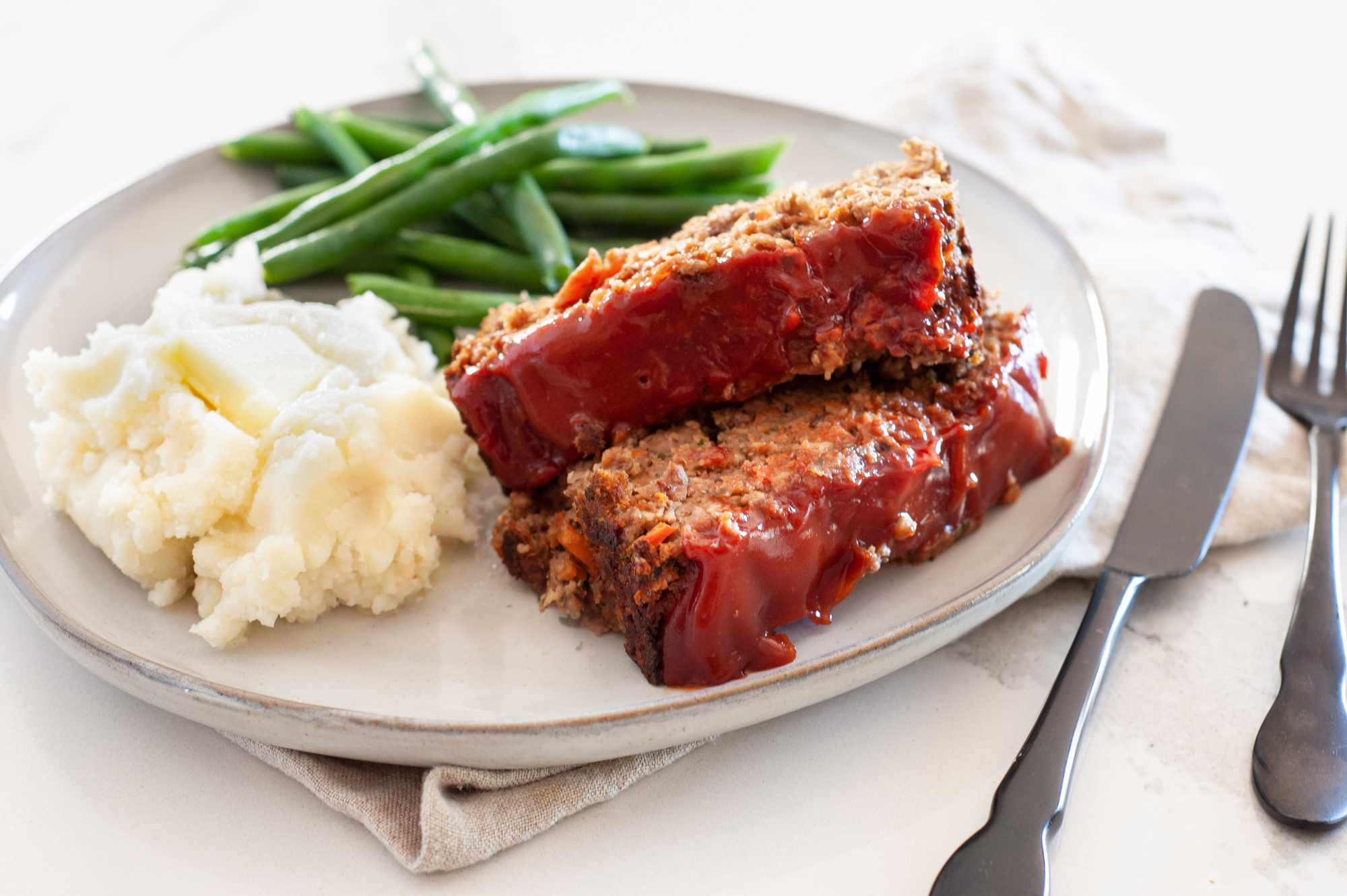 Vegetarian Meatloaf on a Plate with Mashed Potatoes and Green Beans