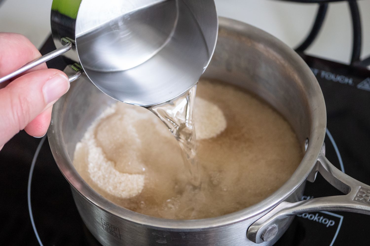 Water Added to Pot of Sugar on a Stove to Make Simply Syrup for Arnold Palmer Recipe