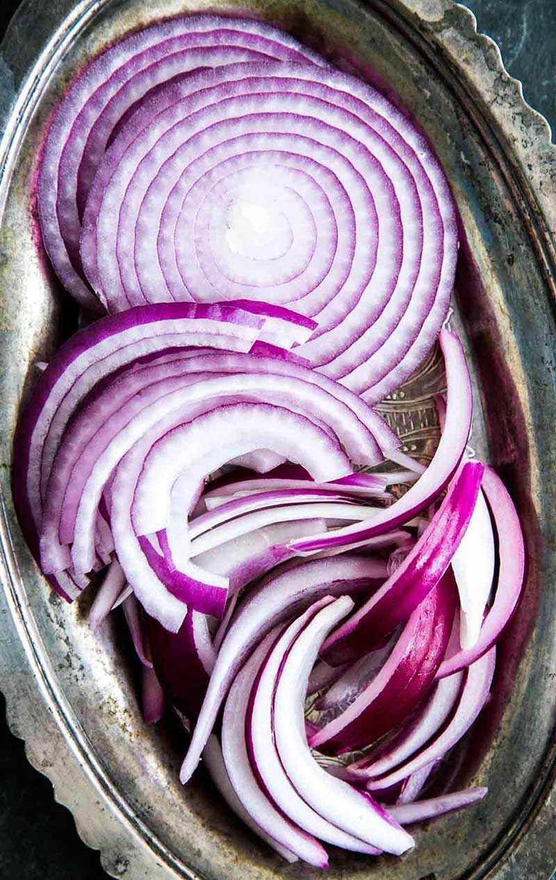 Sliced rings of red onions on a platter