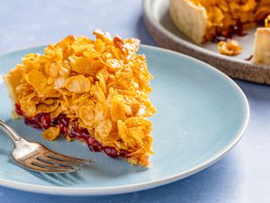slice of cornflake tart on a plate and in the background, the rest of the tart on a plate