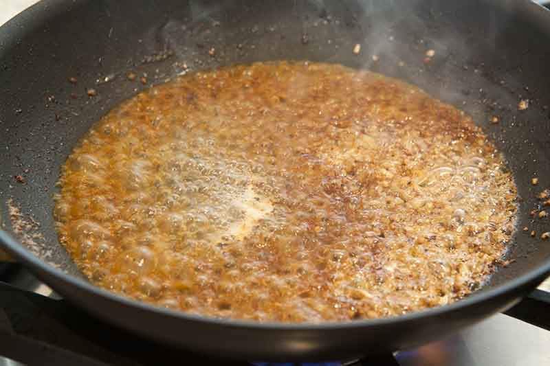 A broth mixture boiling in a wok