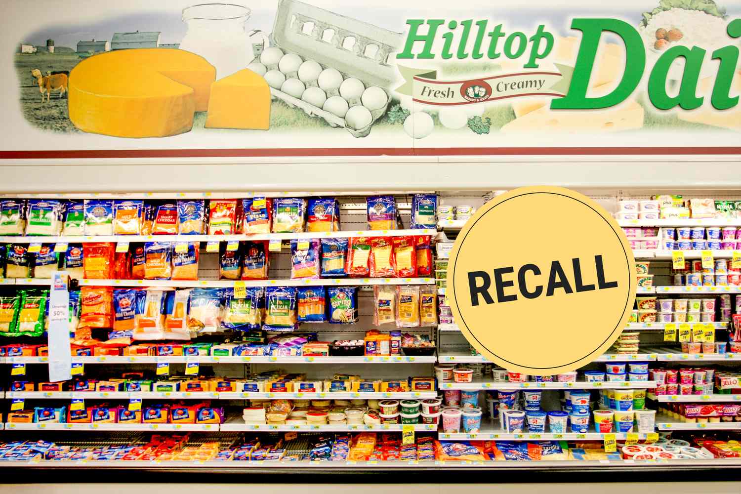 Dairy section shelves in a grocery store with a large recall label displaying various cheese products and other dairy goods