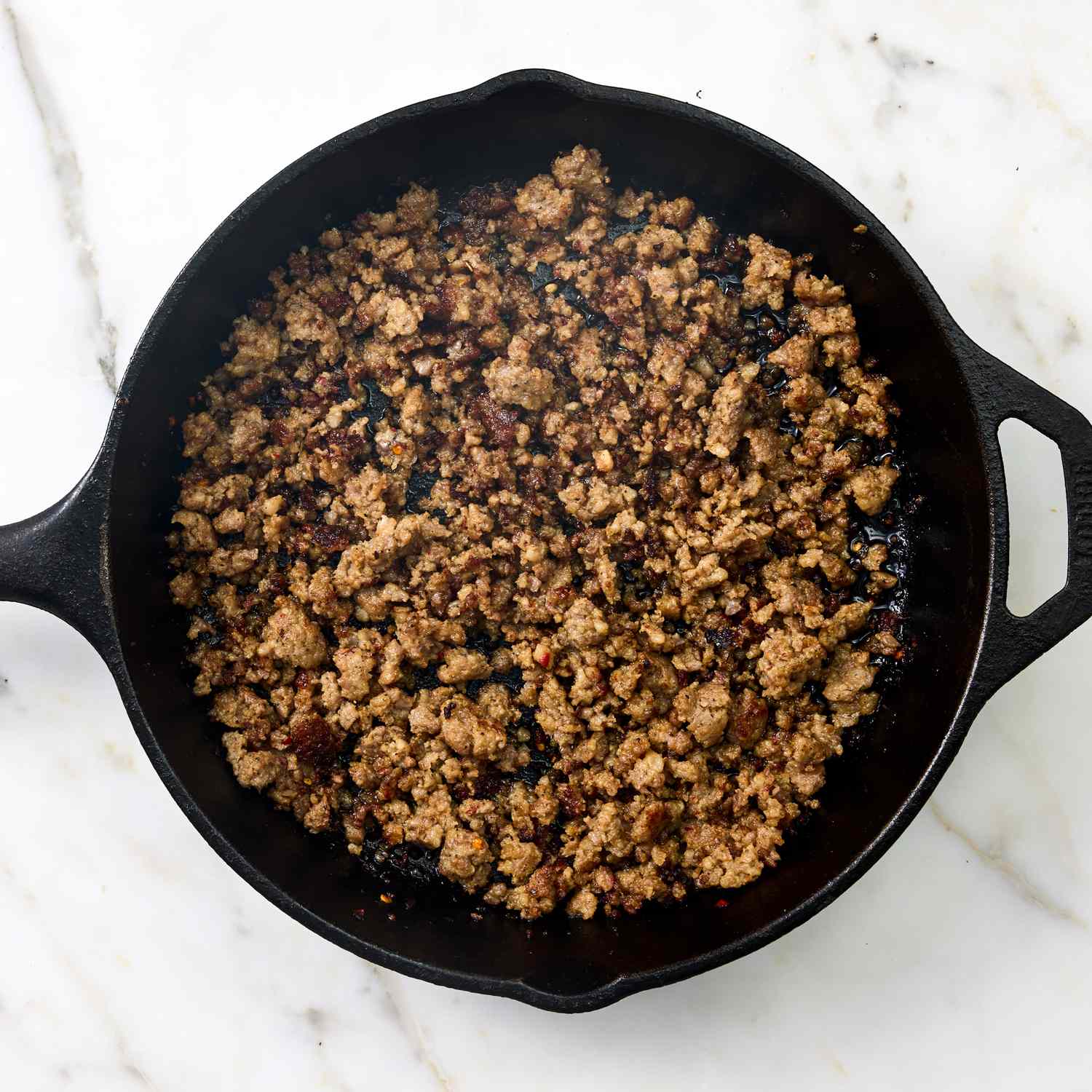 A castiron skillet with cooked ground meat part of a recipe preparation - Hot Cowboy Dip