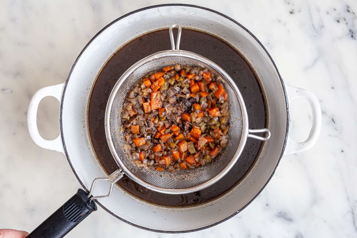 Straining the liquid for an oxtail recipe.