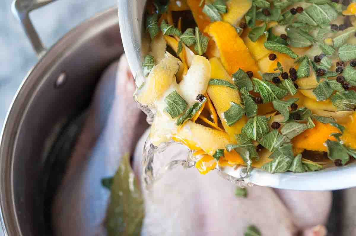 Turkey brine being added to a pot with a turkey in it
