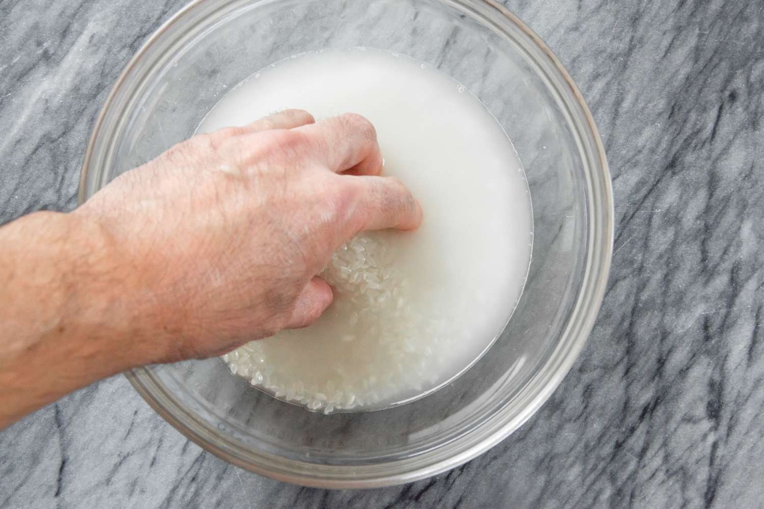 A Hand Washing Rice in a Bowl of Water (Method 2)