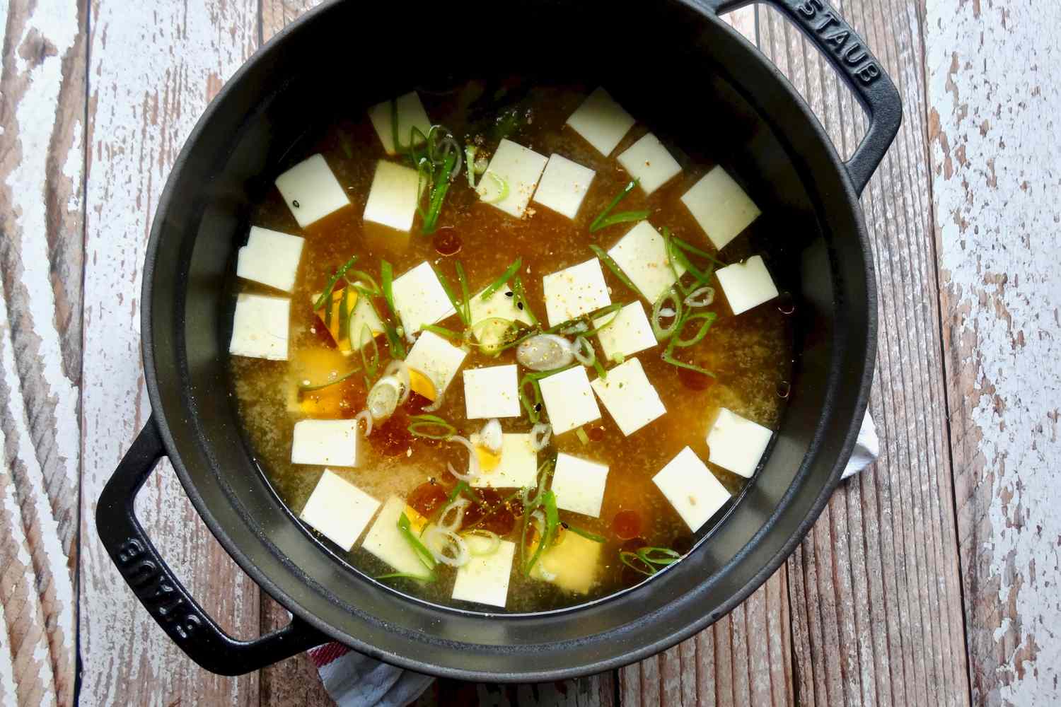Tofu added to miso soup to make a miso soup with sesame oil and togarashi