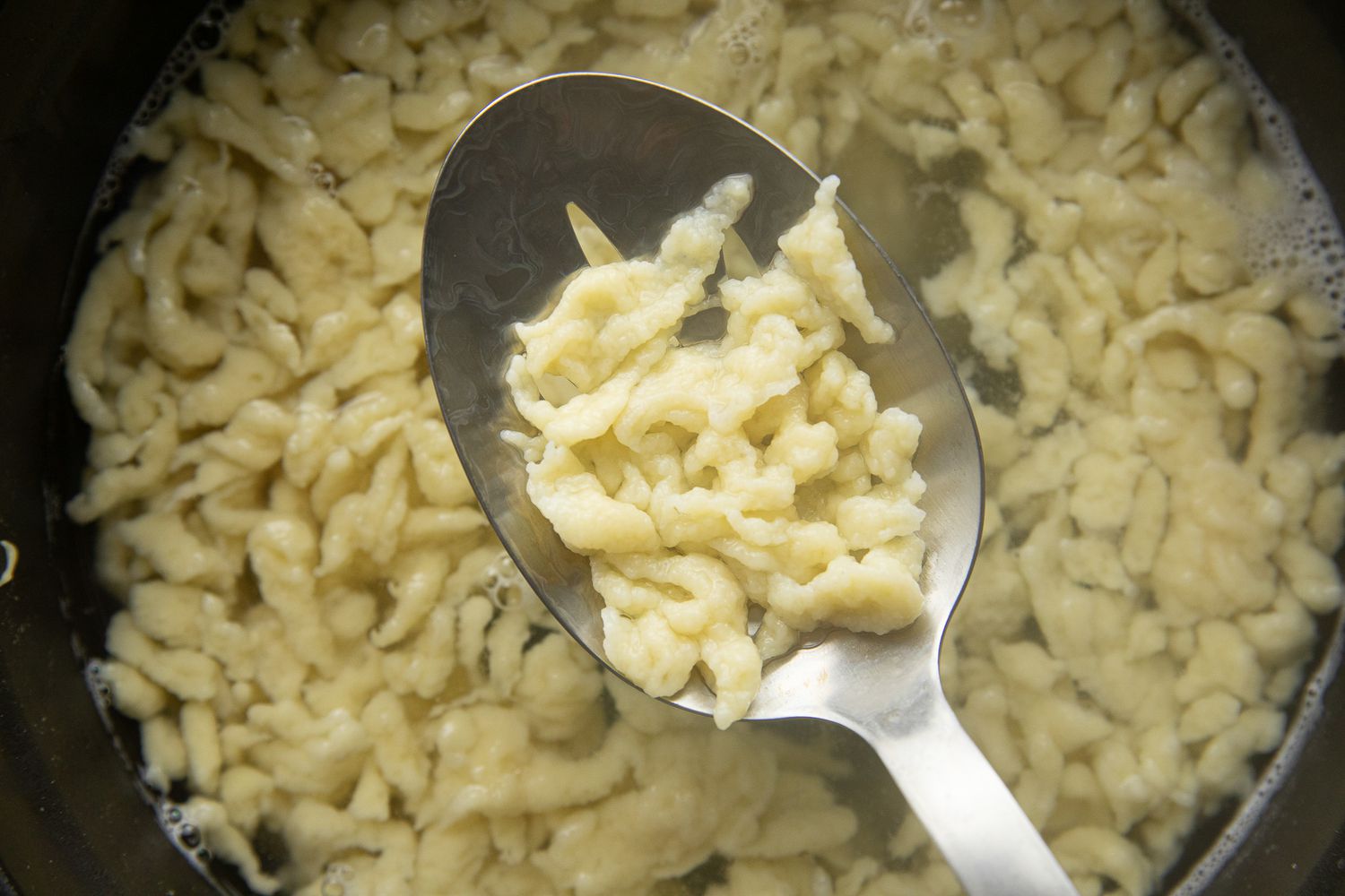 Spoonful of Spätzle Lifted from Pot of Water