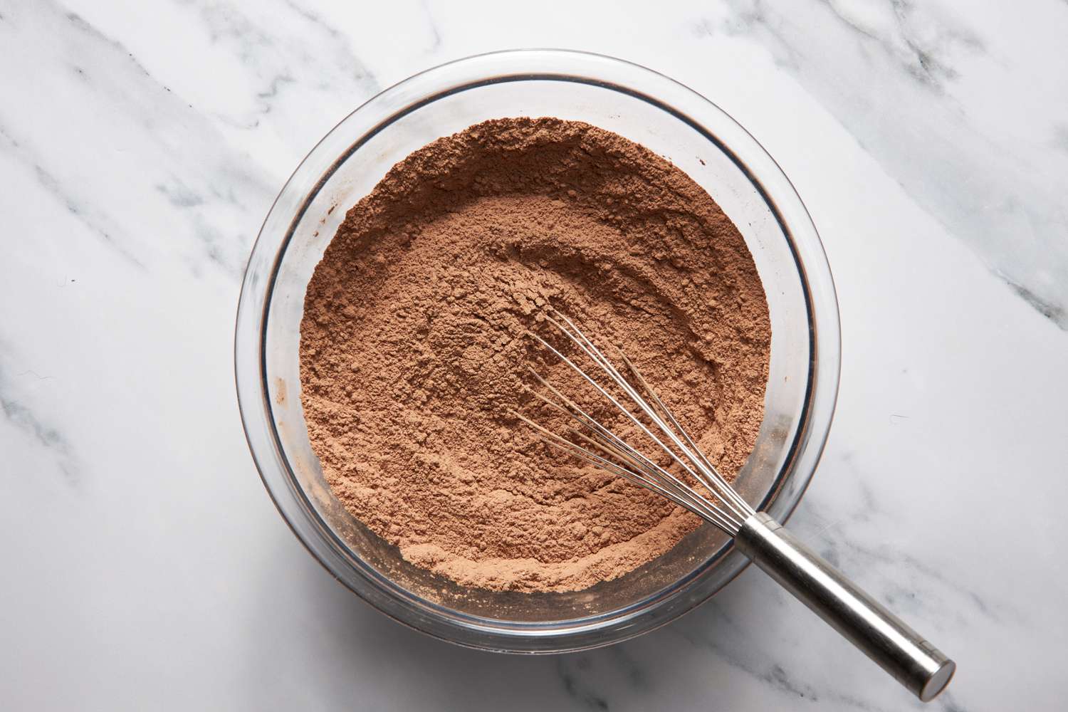 Bumpy cake dry ingredients whisked together in a bowl