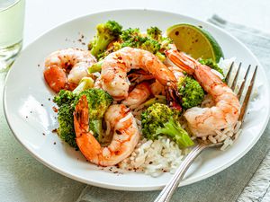 Spicy Honey Roasted Shrimp and Broccoli on a white plate with a fork.