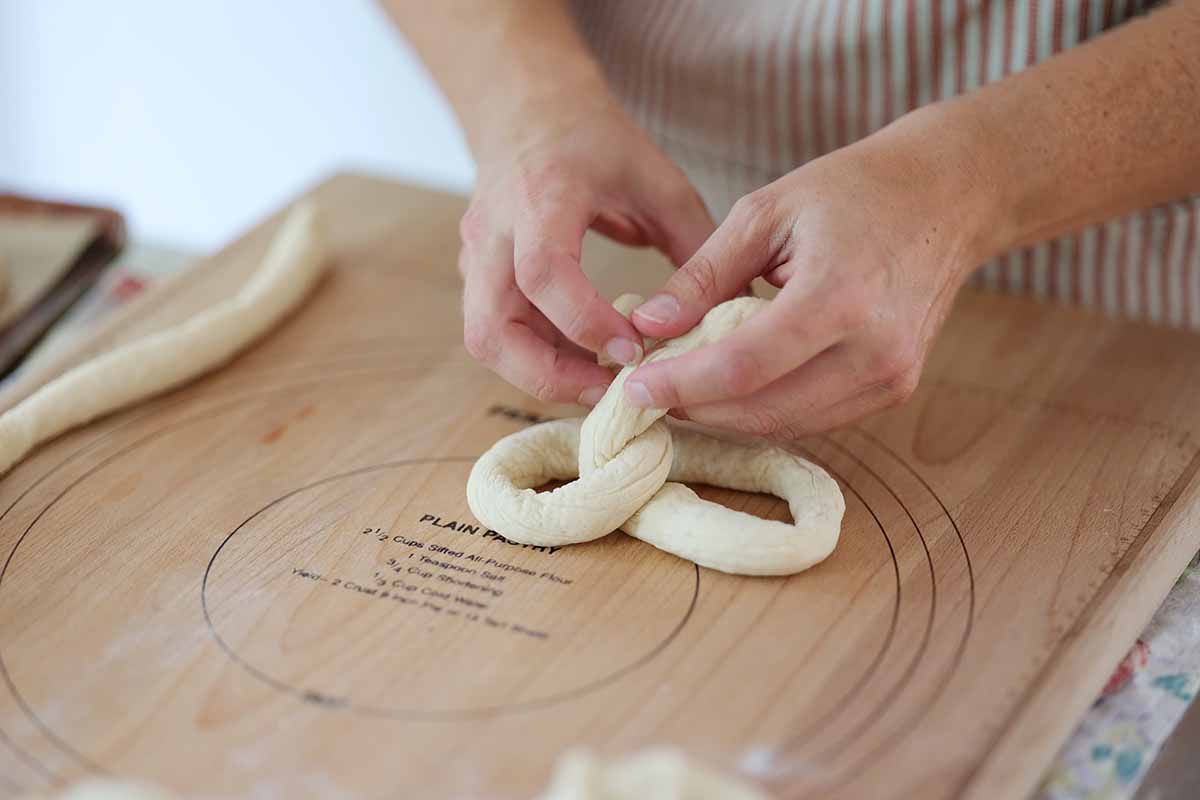 Fold the ends of the rope downward to form the pretzel shape